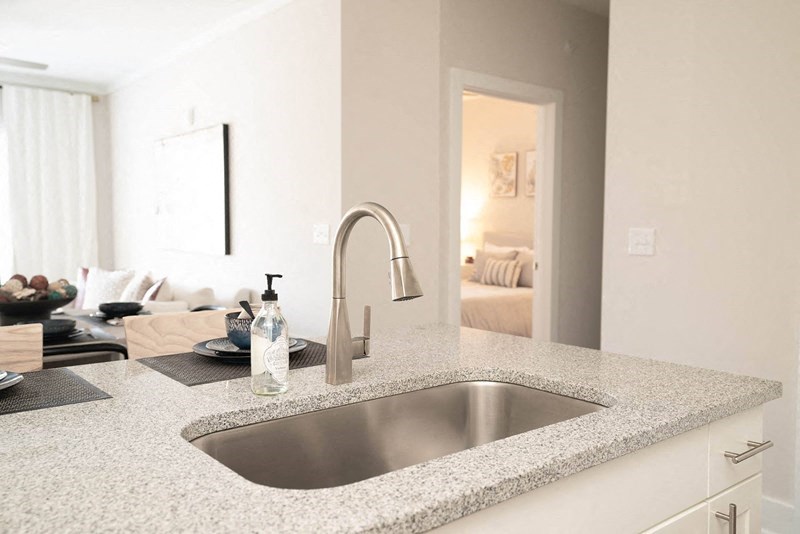 a kitchen sink with a view of a living room