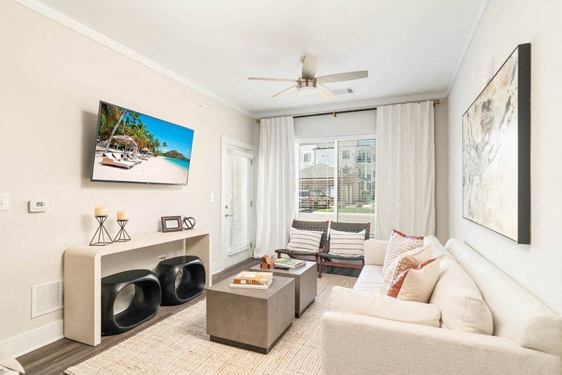 a living room with a white couch and a ceiling fan