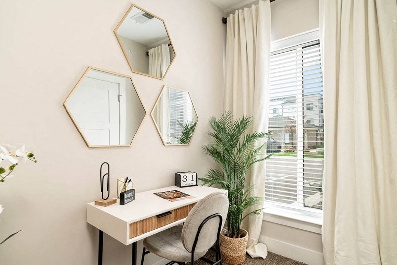 a home office with a desk and a window