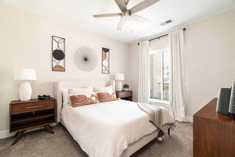a bedroom with a bed and a ceiling fan