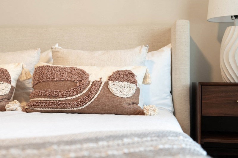 a bed with a pile of pillows on top of it