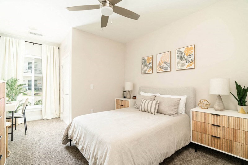 a bedroom with a bed and a ceiling fan