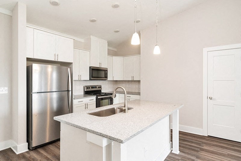 a kitchen with white cabinets and a stainless steel refrigerator