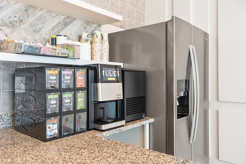 a kitchen with a refrigerator and a coffee machine