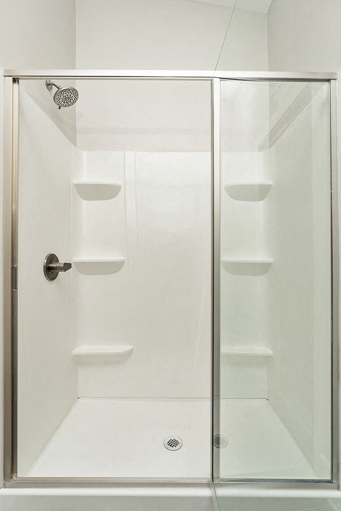 a bathroom with a shower with a glass door