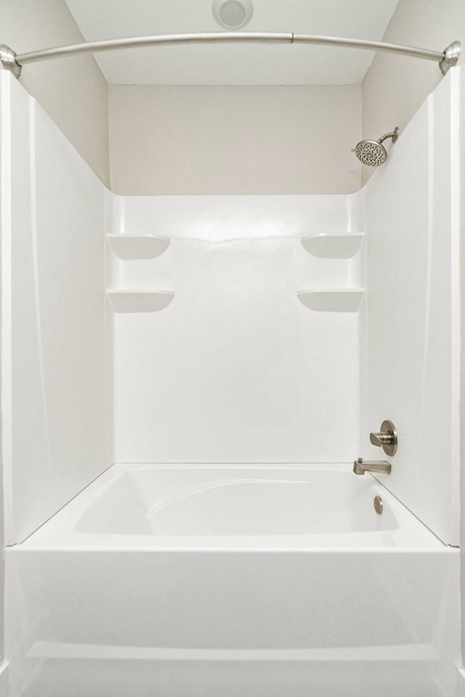 a white bathroom with a shower and a sink