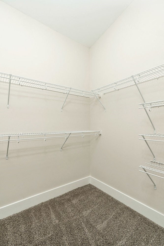 an empty closet with empty shelves in a white room