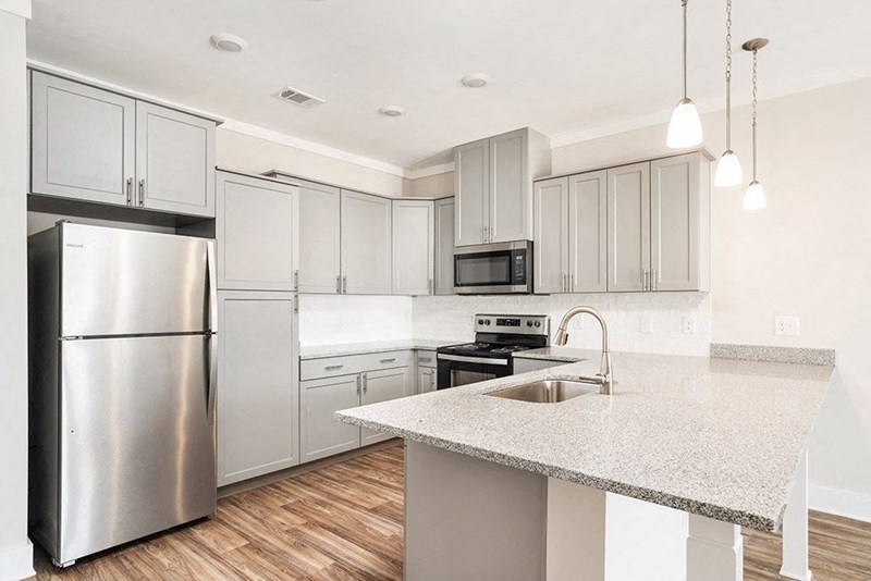 a kitchen with stainless steel appliances and a marble counter top