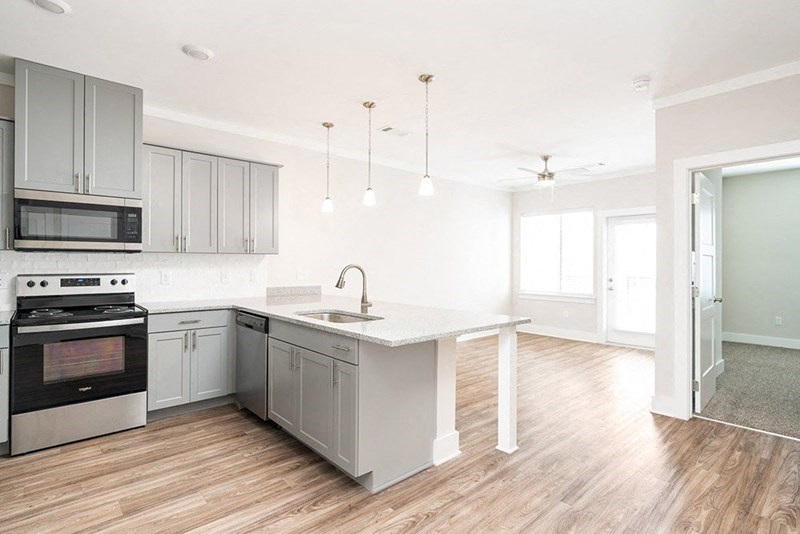 an empty kitchen with white cabinets and stainless steel appliances