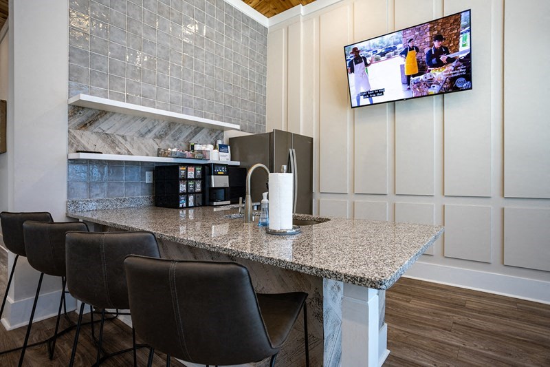 a kitchen with a bar and a television on the wall