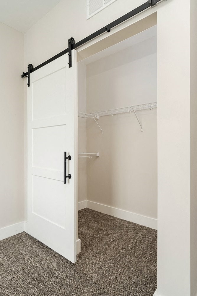 a white sliding barn door in a closet in a home