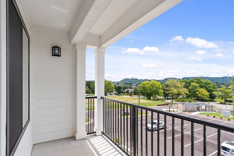 a balcony with a view of a yard and trees