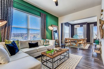 Apartments for Rent Lewisville TX - Hebron 121 Station - Living Room Equipped With Modern Furniture and Dining Room Table With Wooden Chairs - Photo Gallery 2
