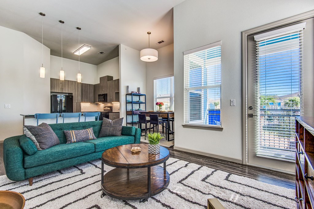 Apartments in Lewisville TX - Hebron 121 Station - Well Lit Living Room with Attached Private Balcony, Wood Plank Flooring, and Furniture