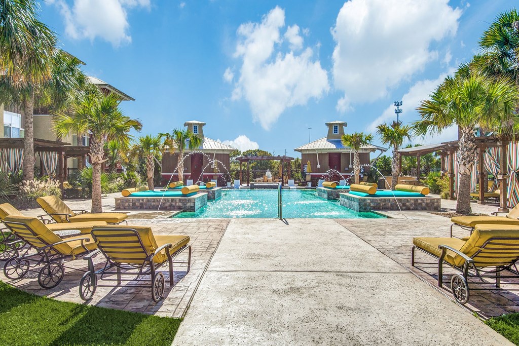 Three-Bedroom Apartments In Lewisville, TX - Hebron 121 Station - Grotto Pool with Tanning Areas, Cabanas, And Lounge Chairs