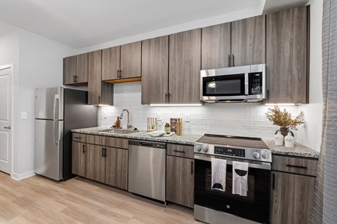 A modern kitchen with wooden cabinets and stainless steel appliances.