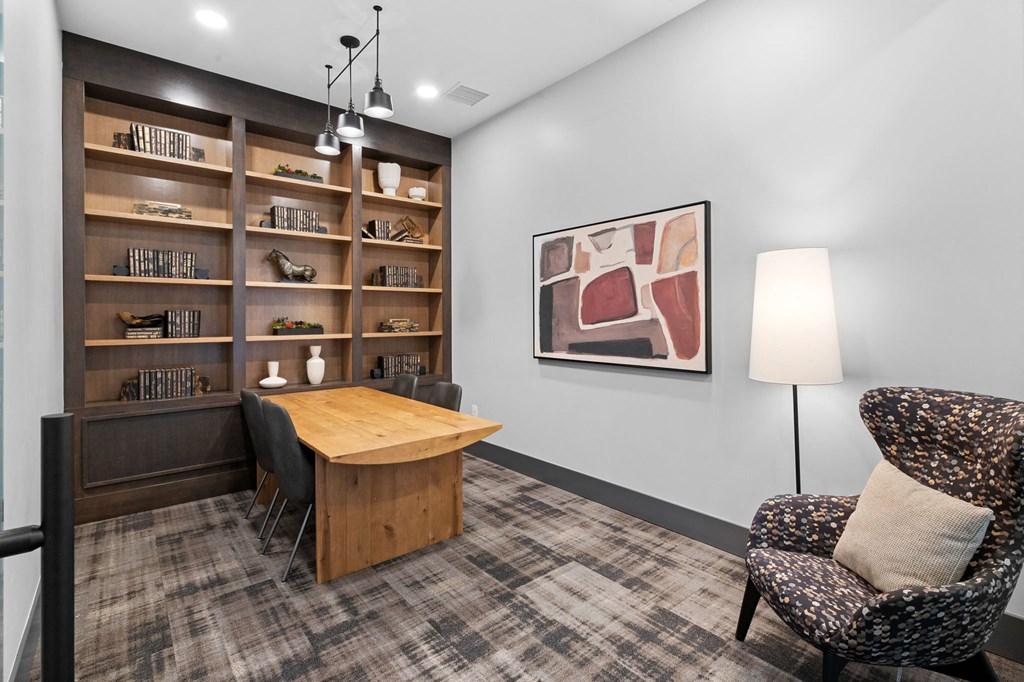 A room with a chair, a table, and a bookshelf.