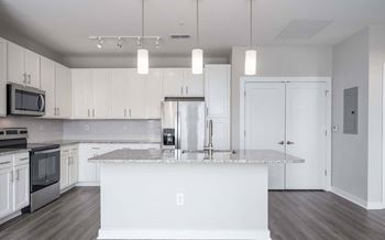 A modern kitchen with white cabinets and a central island.