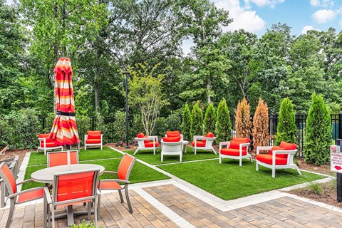a patio with red and white chairs and tables