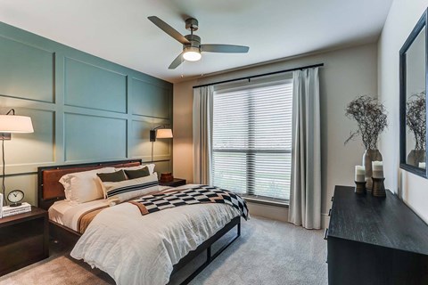 a bedroom with a bed and a ceiling fan