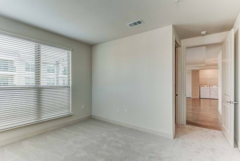 a living room with a large window and a door to a kitchen