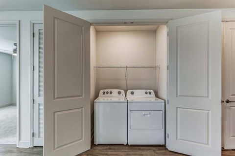 a white washer and dryer in a room with white doors