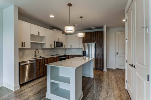 a kitchen with an island and a stainless steel refrigerator