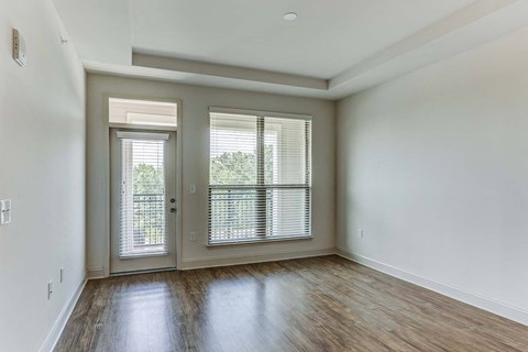 an empty living room with a door and window