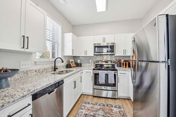 A kitchen with white cabinets and stainless steel appliances.