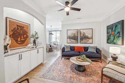 A living room with a couch, a coffee table, and a painting on the wall.