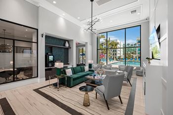 A modern living room with a green sofa and a view of the outside.