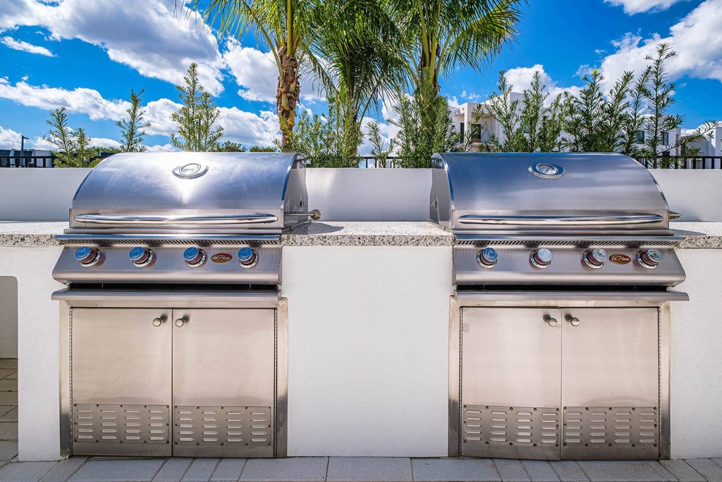two stainless steel bbqs on a patio with trees at Altis Blue Lake, Lake Worth, FL, 33467