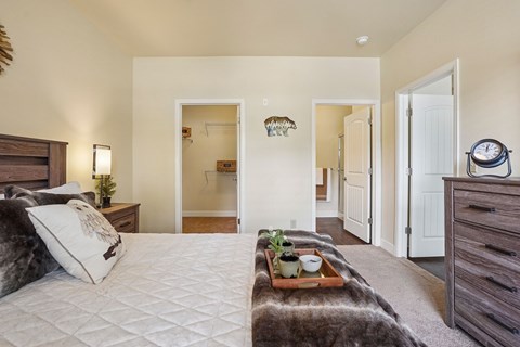 A bedroom with a large bed and a tray with plants and a bowl on it.