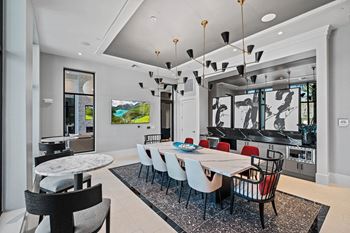 a dining room with a long table and chairs and a kitchen at Altis Grand Suncoast, Land O' Lakes, 34638