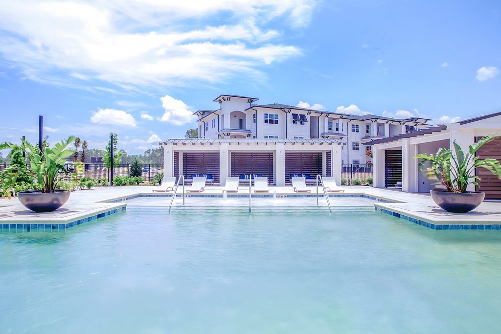 a large swimming pool with a mansion in the background