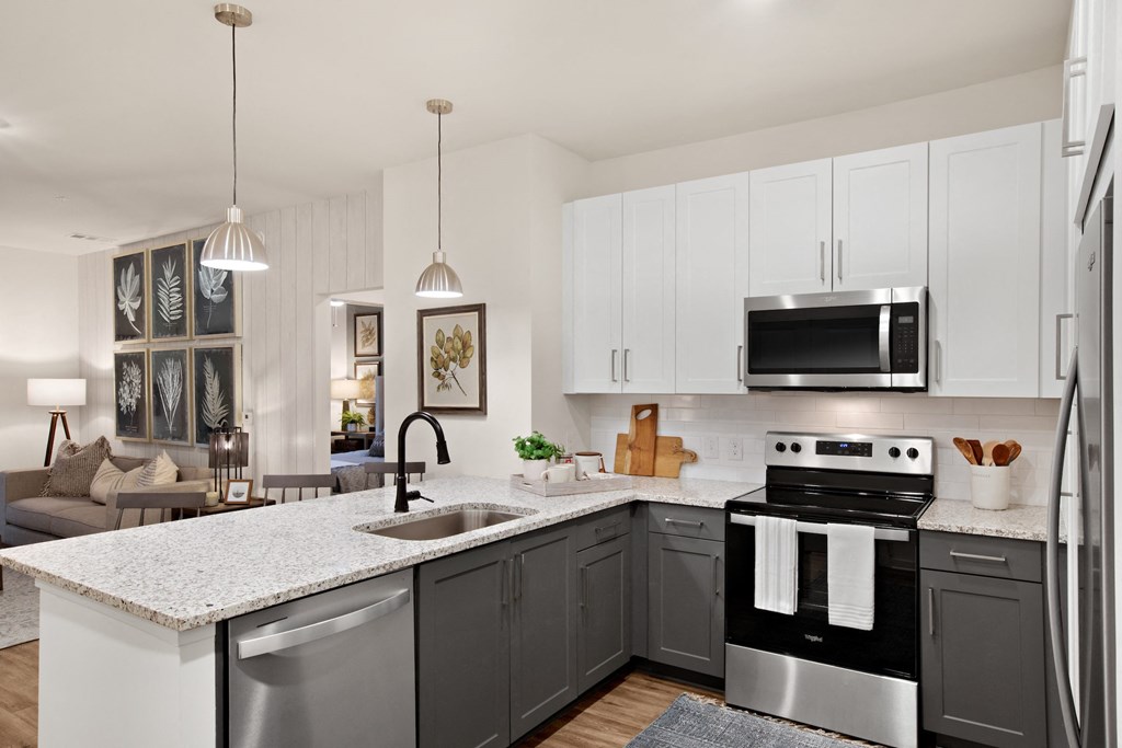 a kitchen with white cabinets and a large island with a sink and a dishwasher