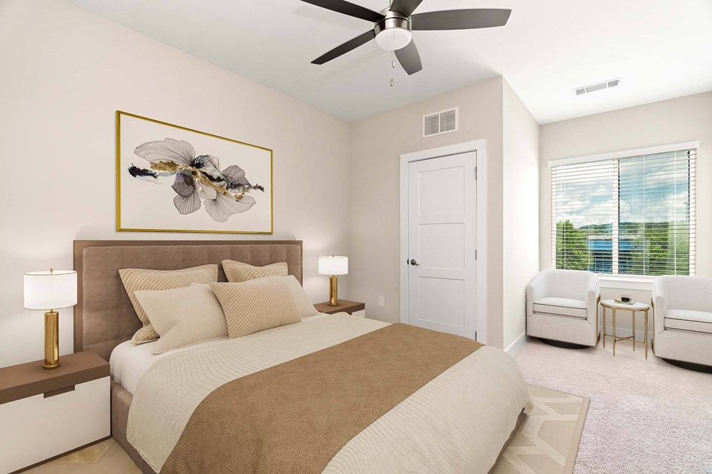 A bedroom with a bed, two lamps, a painting, a chair, and a ceiling fan.