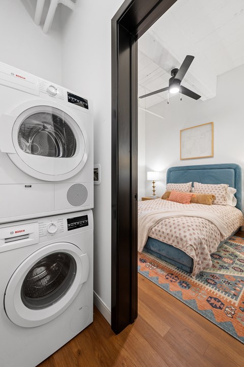a bedroom with a bed and a washer and dryer