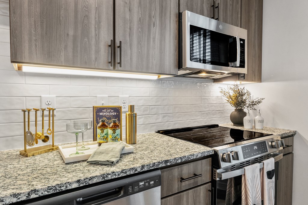 A kitchen with granite countertops and a microwave above the stove.