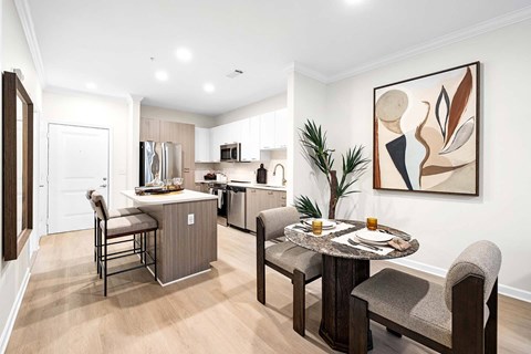 A modern kitchen with a dining table set for two.