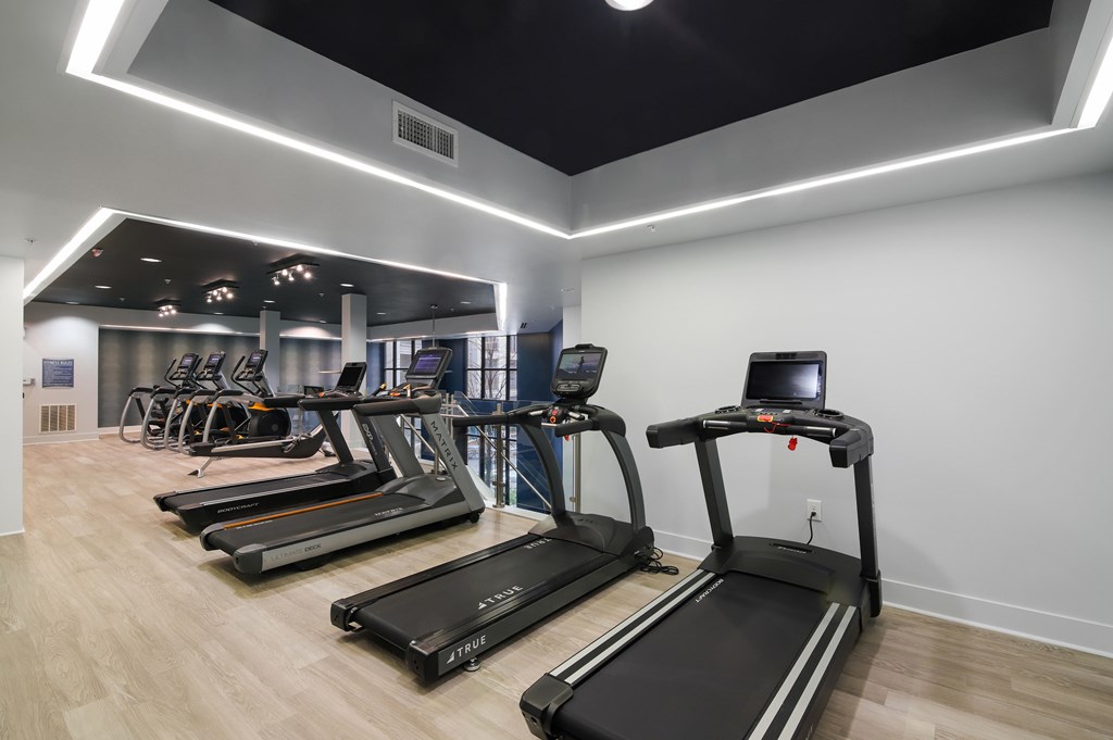 A gym with treadmills and elliptical machines.