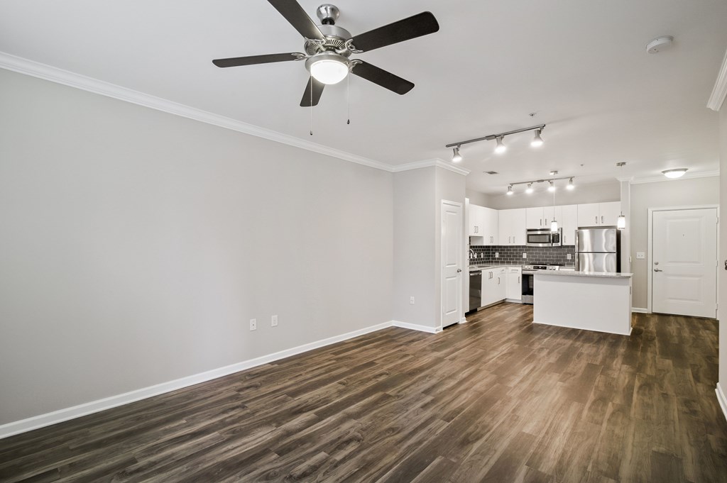 A room with a ceiling fan and wooden flooring.