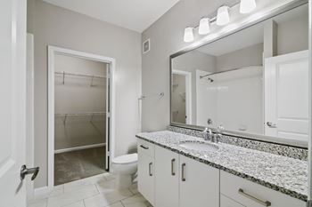 A bathroom with a sink, mirror, and a walk-in shower.