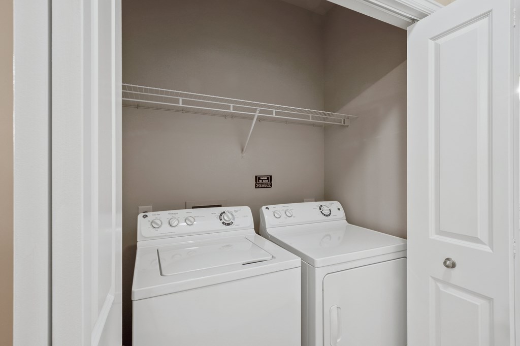 A white washer and dryer in a small laundry room.