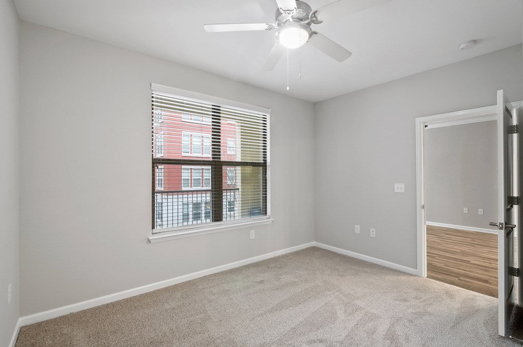A room with a window and a ceiling fan.