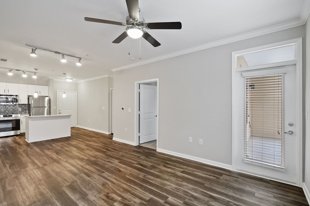 A room with a ceiling fan and wooden flooring.