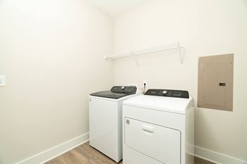 A white washing machine and dryer in a small laundry room.