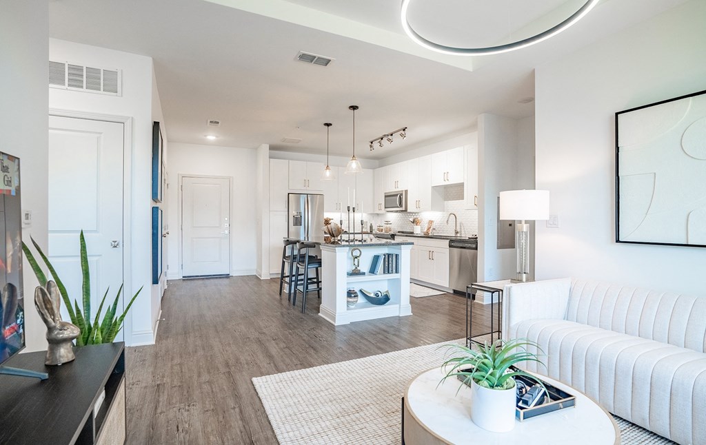 a living room and kitchen with a white couch and a table