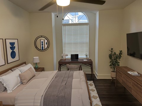 A bedroom with a large bed and a ceiling fan.