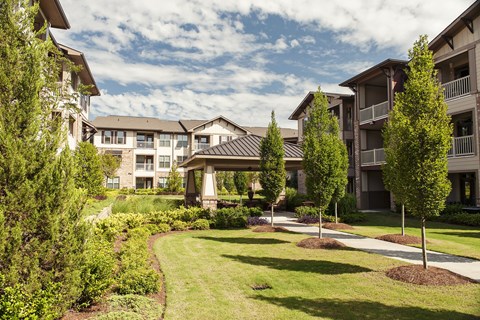 A row of apartment buildings with a well-manicured lawn in front.